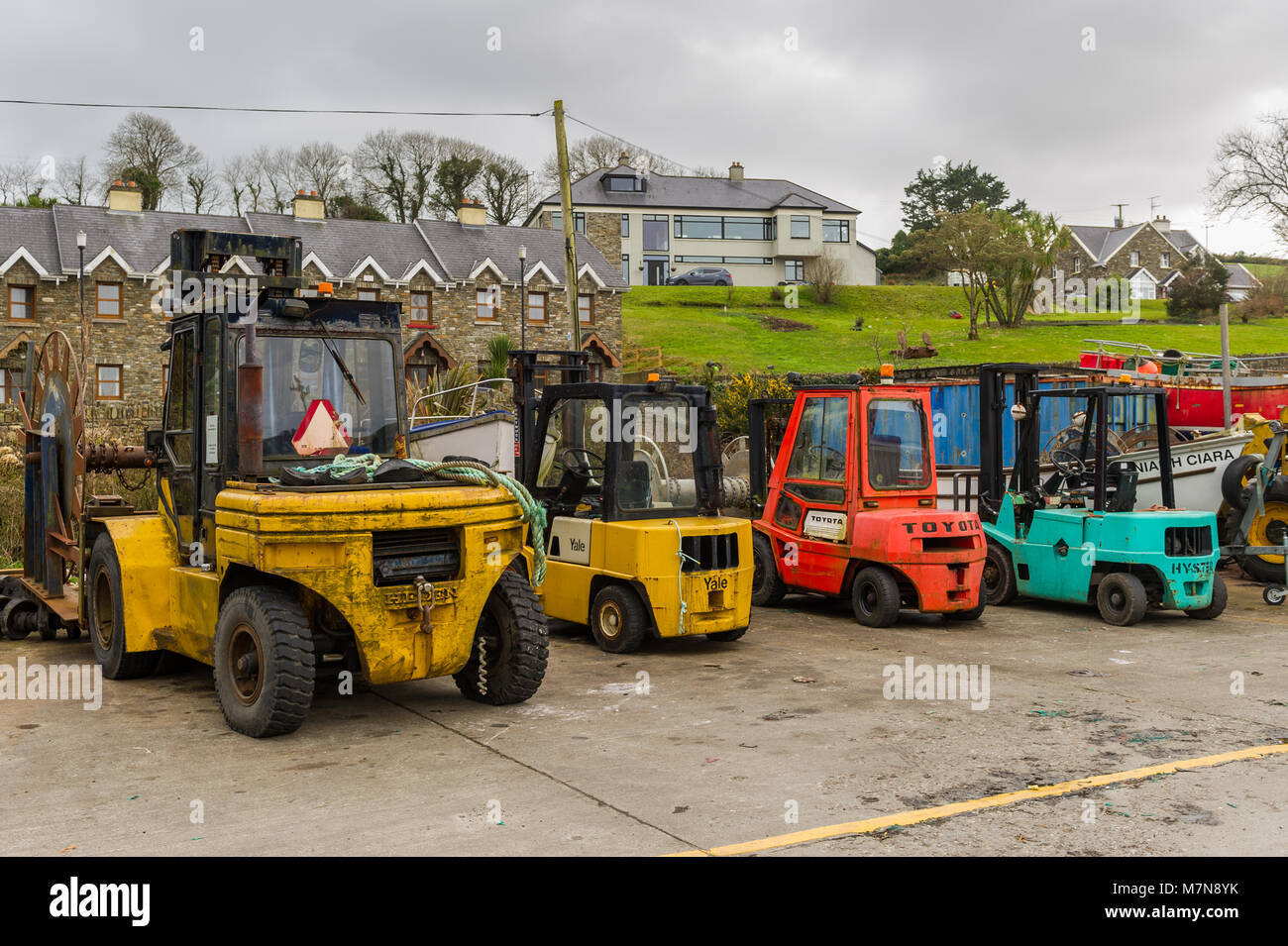 Fork lift trucks lined up on the dock at Union Hall Fishing Port, West Cork, Ireland. Stock Photo