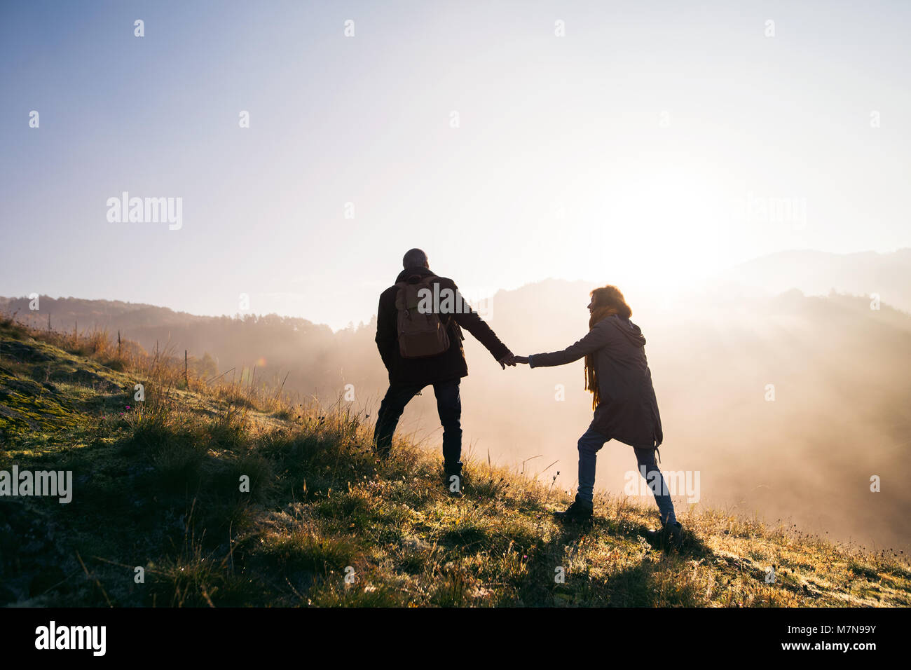 Senior couple on a walk in an autumn nature at sunrise. Stock Photo