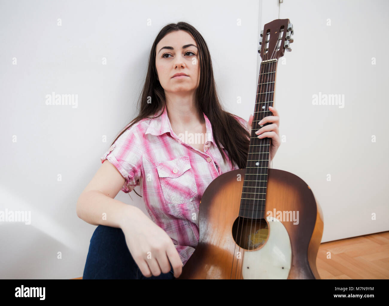 Beautiful young woman with acoustic guitar at home Stock Photo - Alamy