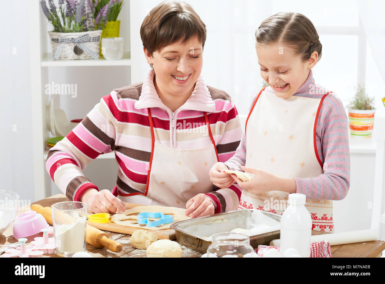 Mother and daughter cooking at home, making the dough for buns Stock ...