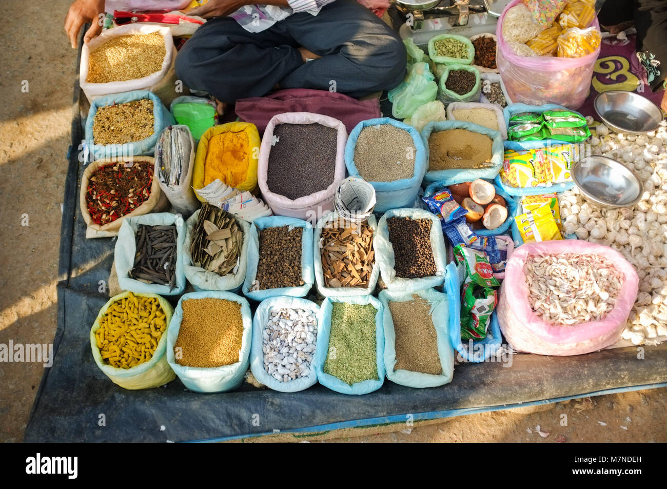 GOA, INDIA- FEBRUARY 2, 2015: Street salesman sitting at spice stand. Stock Photo