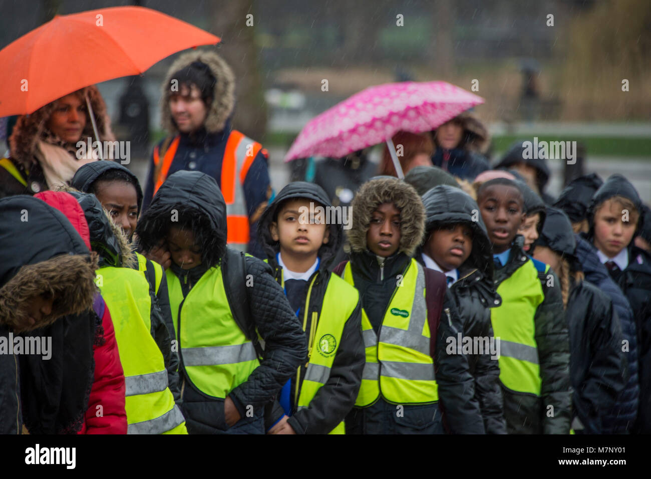 London, UK. 12th March, 2018. The rain fell dampening some spirits - The Band of the Coldstream Guards accompanies 400 members of the Commonwealth Children’s Choir in a musical celebration of Commonwealth Day 2018. The performance, on Horse Guards parade, included a world premiere of a new composition, “To be a Friend”, dedicated to Her Majesty The Queen (and marking the Commonwealth Heads of Government Meeting (CHOGM) being held in London in April 2018). It was composed by Major Simon Haw MBE. Credit: Guy Bell/Alamy Live News Stock Photo