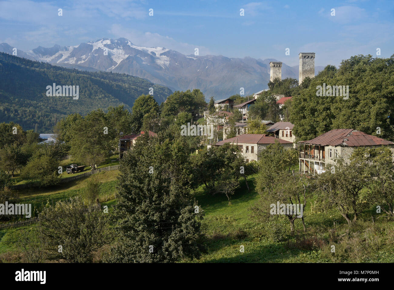 Historic tower houses stand amid more modern homes on a hillside in Mestia, Svaneti region of the Caucasus Mountains, Georgia Stock Photo