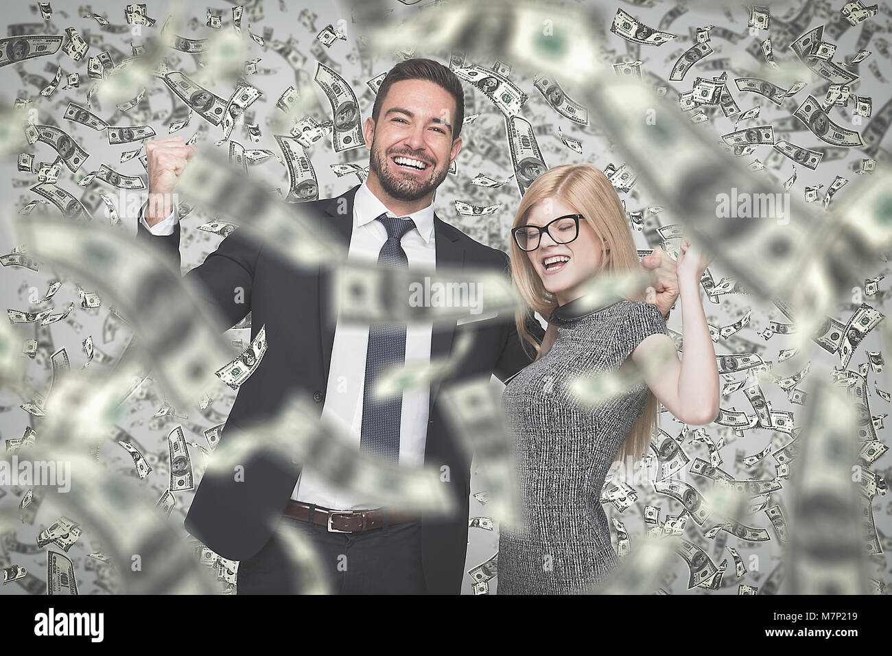 Happy young caucasian businessman and businesswoman in money rain, winning contract or lottery Stock Photo