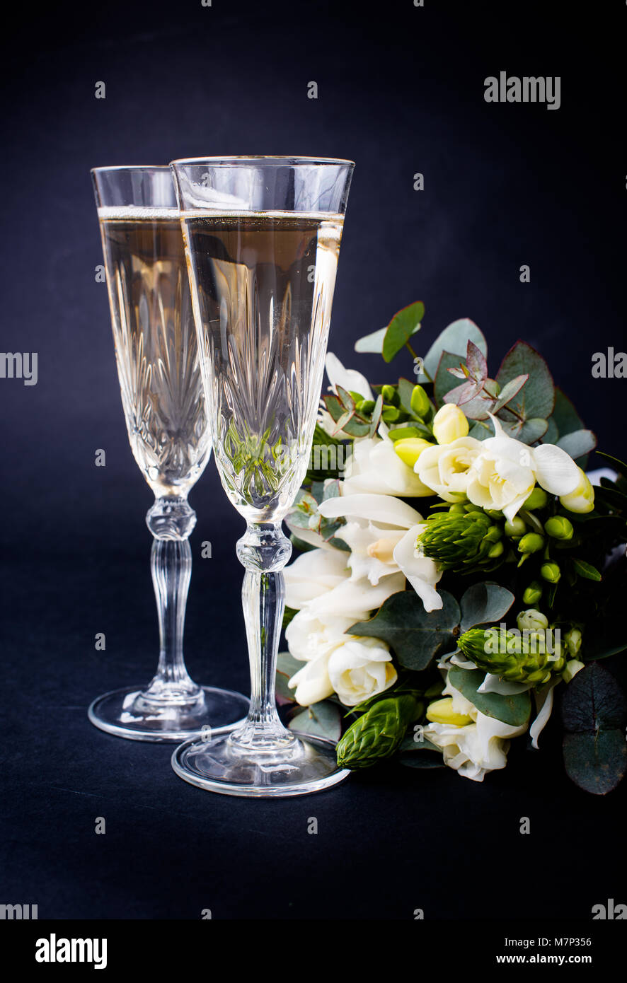 Two glasses of champagne and bouquet of white flowers Stock Photo - Alamy