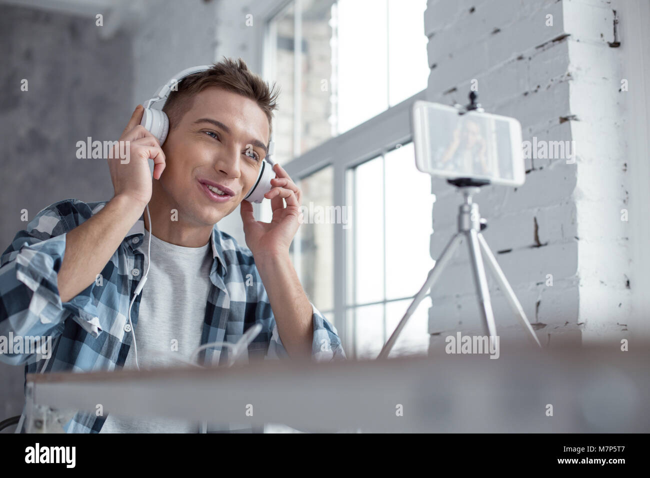 Delighted vlogger wearing great headphones Stock Photo
