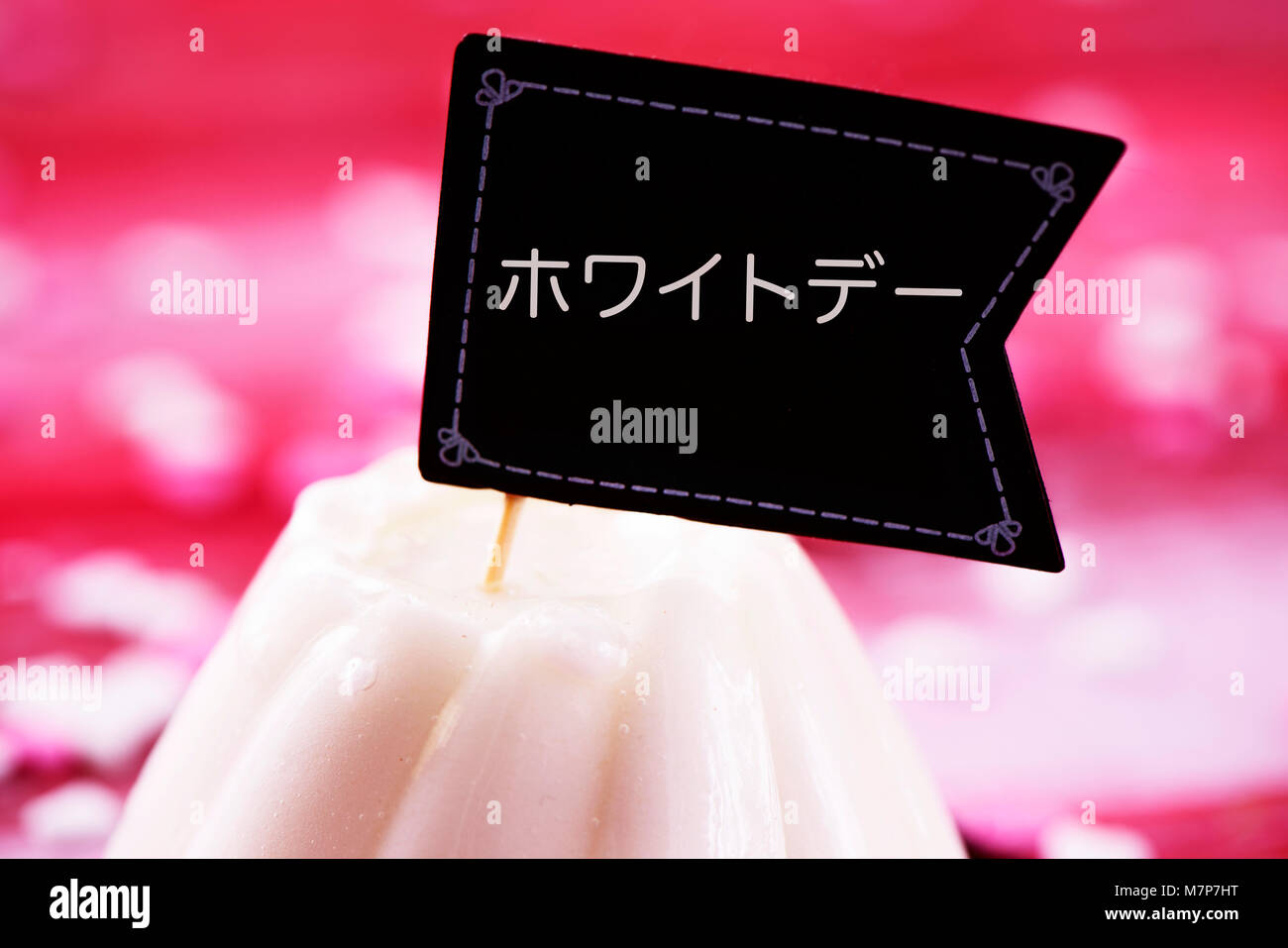 a white cake topped with a flag-shaped signboard with the text white day written in japanese, the popular asian festivity observed by women presenting Stock Photo