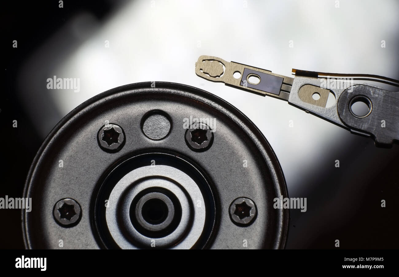 Internal view of computer laptop hard drive showing read write head and magnetic disk. Stock Photo