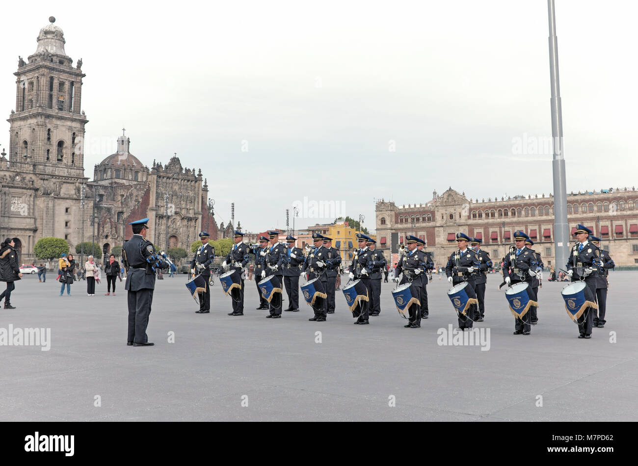 The Mexico City Auxiliary Police band performs in the vast historic zocalo with the Mexico City Metropolitan Cathedral and National Palace in the back Stock Photo