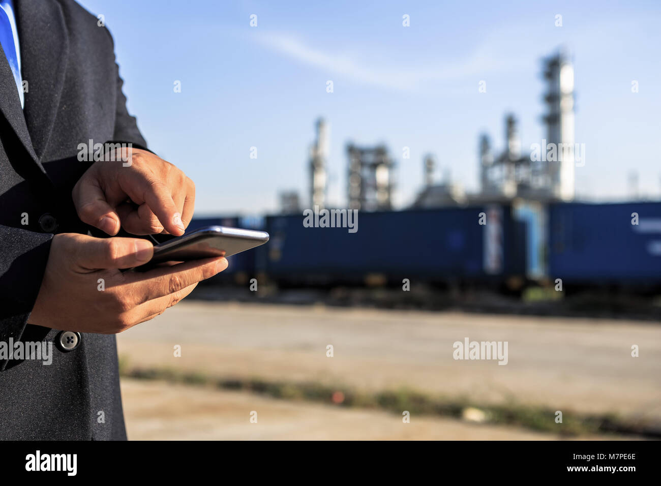 Businessman checking around oil refinery plant with clear sky Stock