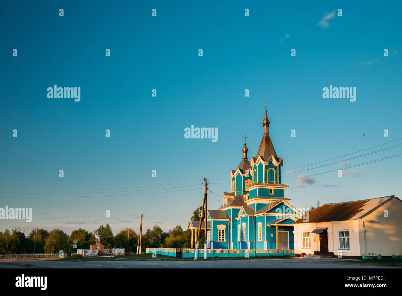 Krasnyy Partizan, Dobrush District, Gomel Region, Belarus. Old Wooden Orthodox Church of the Nativity of the Virgin Mary At Sunset In Village Stock Photo