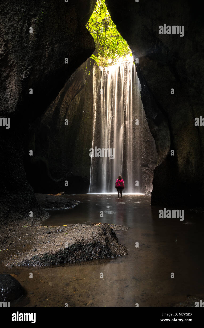 The wonderful sunbeam coming from the top of a huge waterfall inside a cave in Bali Stock Photo