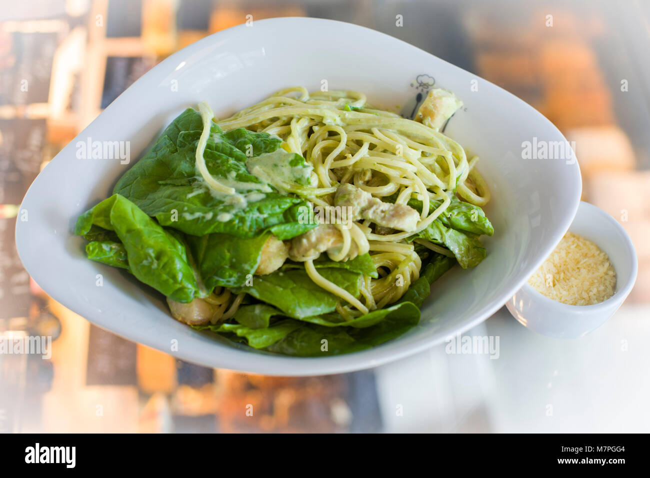Pasta, prepared with cheese, green, meat, and served in oval deep porcelaine plate Stock Photo