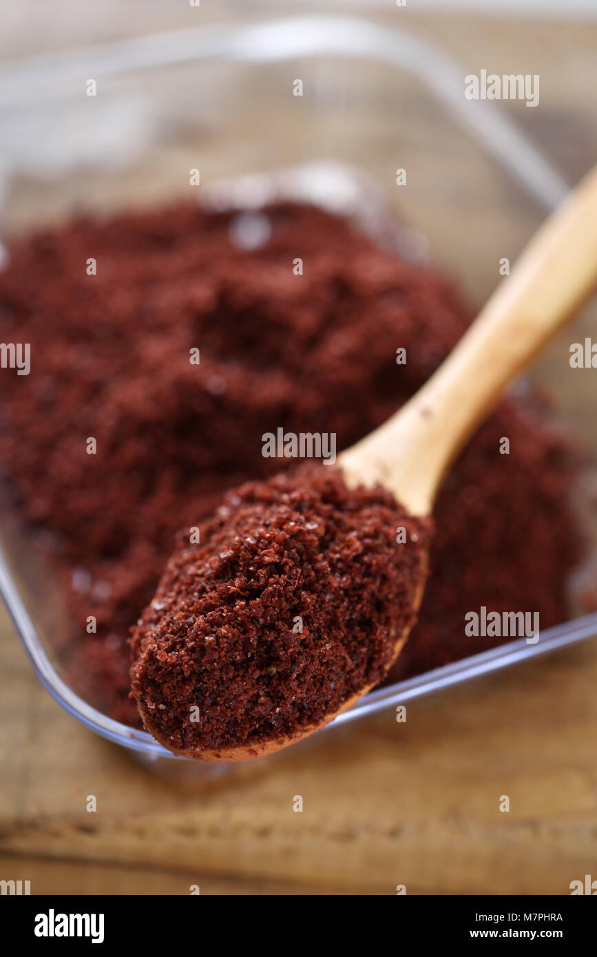 Middle Eastern spice Sumak in a wooden spoon. Selective focus on the