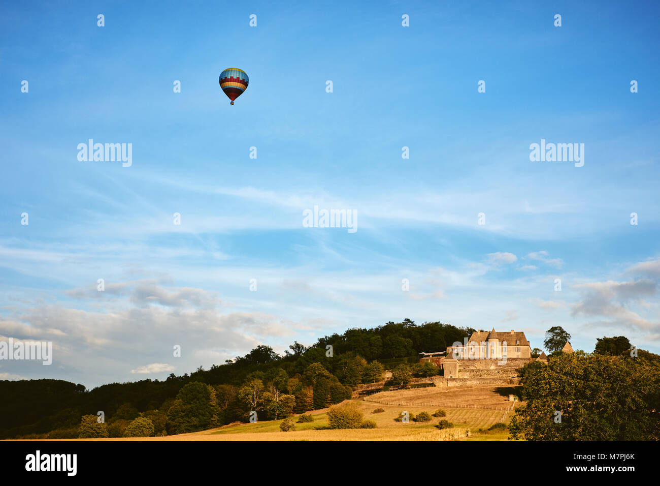 A hot air balloon glides over the Château de Marqueyssac a 17th-century château and gardens located at Vézac, in the Dordogne Department of France. Stock Photo