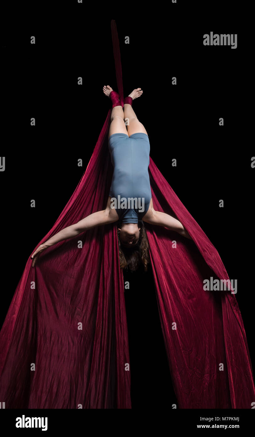 Graceful aerial dancer woman doing her performance isolated on black