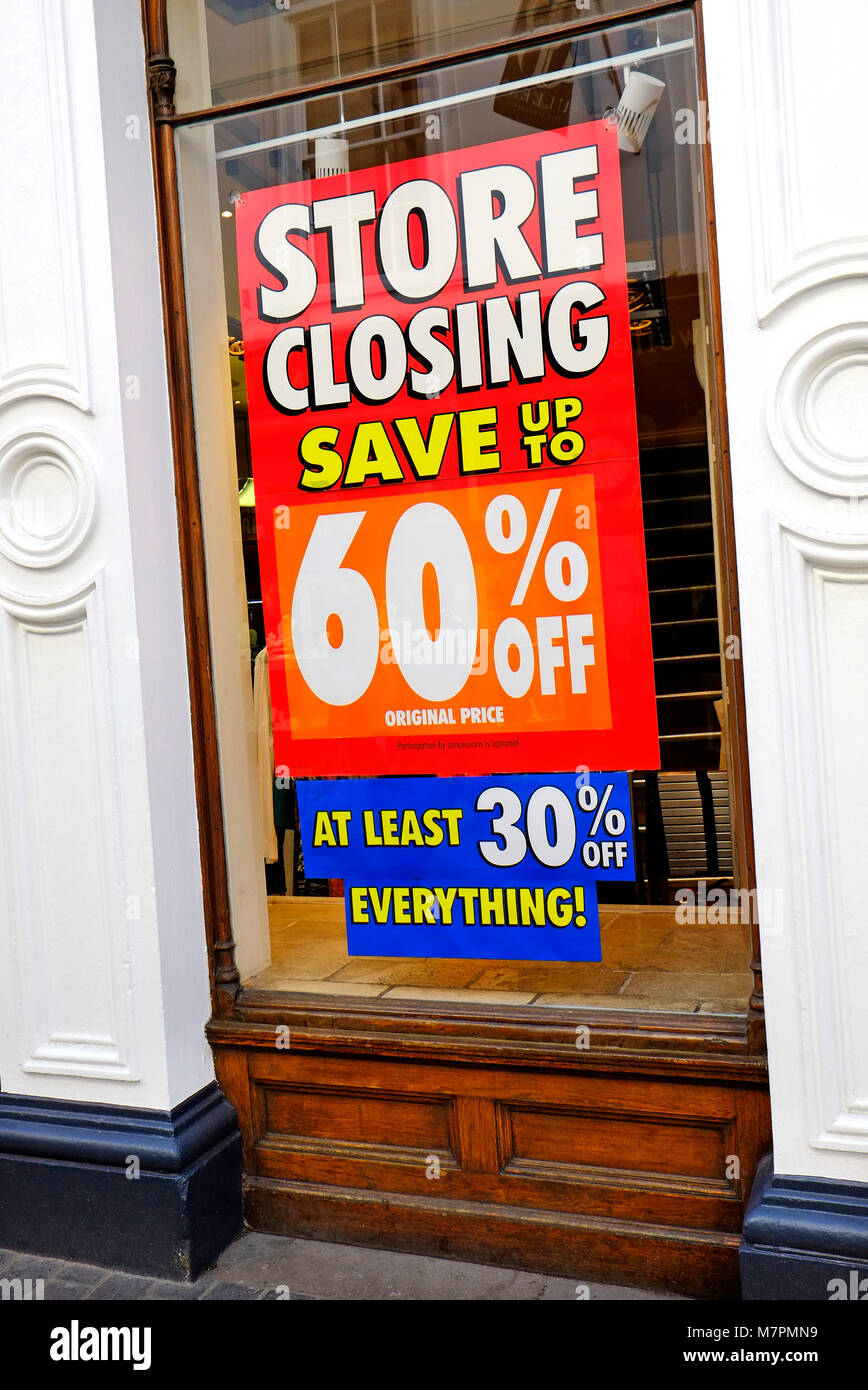 store closing down sale poster in shop window Stock Photo