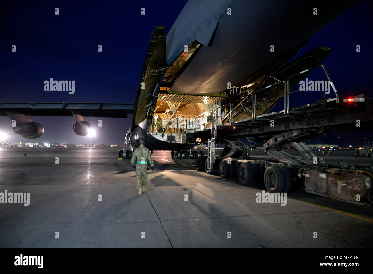 U.S. Air Force Airmen with the 455th Expeditionary Aerial Port Squadron load cargo into a C-17 Globemaster III loadmaster Sept. 9, 2014. Airmen assigned to the 455 EAPS have serviced more than 14,300 missions and 114,700 short tons of cargo since the beginning of the year to support Operation Enduring Freedom. (U.S. Air Force photo by Staff Sgt. Evelyn Chavez/Released) 455th Air Expeditionary Wing Bagram Airfield, Afghanistan Stock Photo