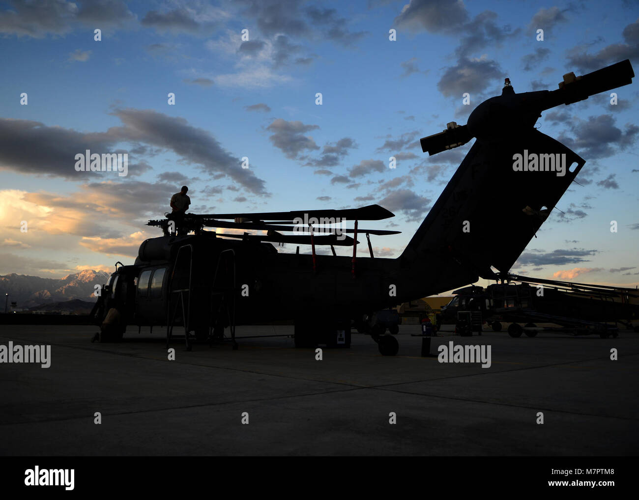 U. S. Air Force Airmen from the 455th Expeditionary Aircraft Maintenance Squadron, break down an HH-60G Pave Hawk helicopter at Bagram Airfield, Afghanistan June 2, 2014.  The unit is preparing the helicopter for redeployment to their home base Moody Air Force Base, Ga.  Helicopter maintainers here ensure Bagram’s combat search and rescue helicopters are ready to fly at a moment’s notice. (U.S. Air Force photo by Staff Sgt. Evelyn Chavez/Released) 455th Air Expeditionary Wing Bagram Airfield, Afghanistan Stock Photo