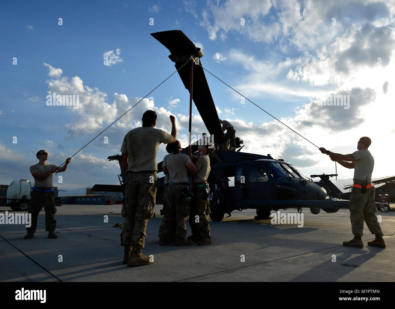 U. S. Air Force Airmen from the 455th Expeditionary Aircraft Maintenance Squadron, break down an HH-60G Pave Hawk helicopter at Bagram Airfield, Afghanistan June 2, 2014.  The unit is preparing the helicopter for redeployment to their home base Moody Air Force Base, Ga.  Helicopter maintainers here ensure Bagram’s combat search and rescue helicopters are ready to fly at a moment’s notice. (U.S. Air Force photo by Staff Sgt. Evelyn Chavez/Released) 455th Air Expeditionary Wing Bagram Airfield, Afghanistan Stock Photo
