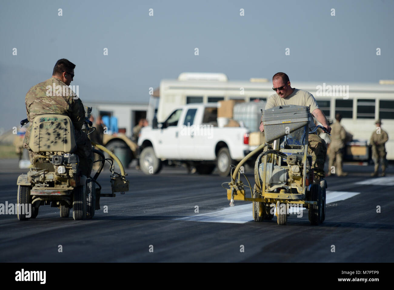 U.S. Air Force Airmen with the 455th Expeditionary Civil Engineer Squadron, paint the flightline at Bagram Airfield, Afghanistan June 8, 2014. The 455 ECES ensures operability of the airfield by providing airfield maintenance, construction and operation for the senior airfield authority mission. (U.S. Air Force photo by Master Sgt. Cohen A. Young/Released) 455th Air Expeditionary Wing Bagram Airfield, Afghanistan Stock Photo