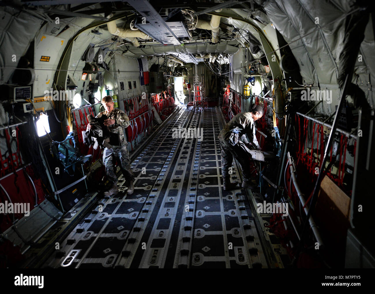 (From left) U.S. Air Force Senior Airman Ryan Jelstrom, 774th Expeditionary Airlift Squadron aircrew flight equipment specialist and Staff Sgt. Nancy Kendrick, aircrew flight equipment non-commissioned officer-in-charge inspect aircrew body armor on a C-130J Super Hercules at Bagram Airfield, Afghanistan June 18, 2014.  As part of aircrew flight equipment, they are responsible for ensuring aircrew equipment such as helmets, oxygen masks, parachutes and night vision goggles are serviceable for every mission. Jelstrom is deployed from Dyess Air Force Base, Texas and a native of Cayucos, Calif.   Stock Photo