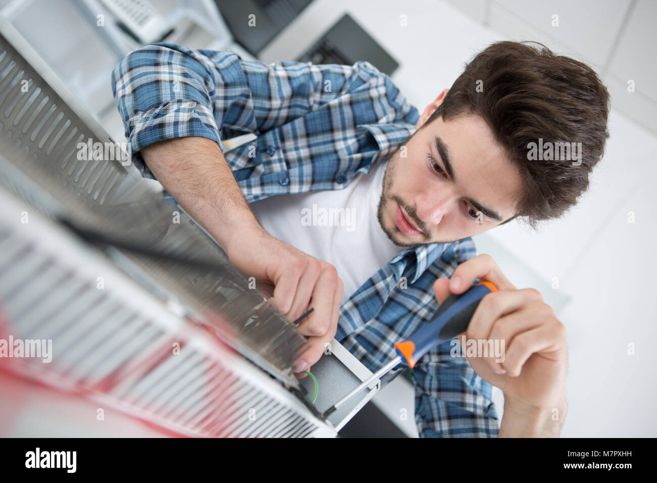 repairman fixing a gas water heater with a screwdriver Stock Photo Alamy