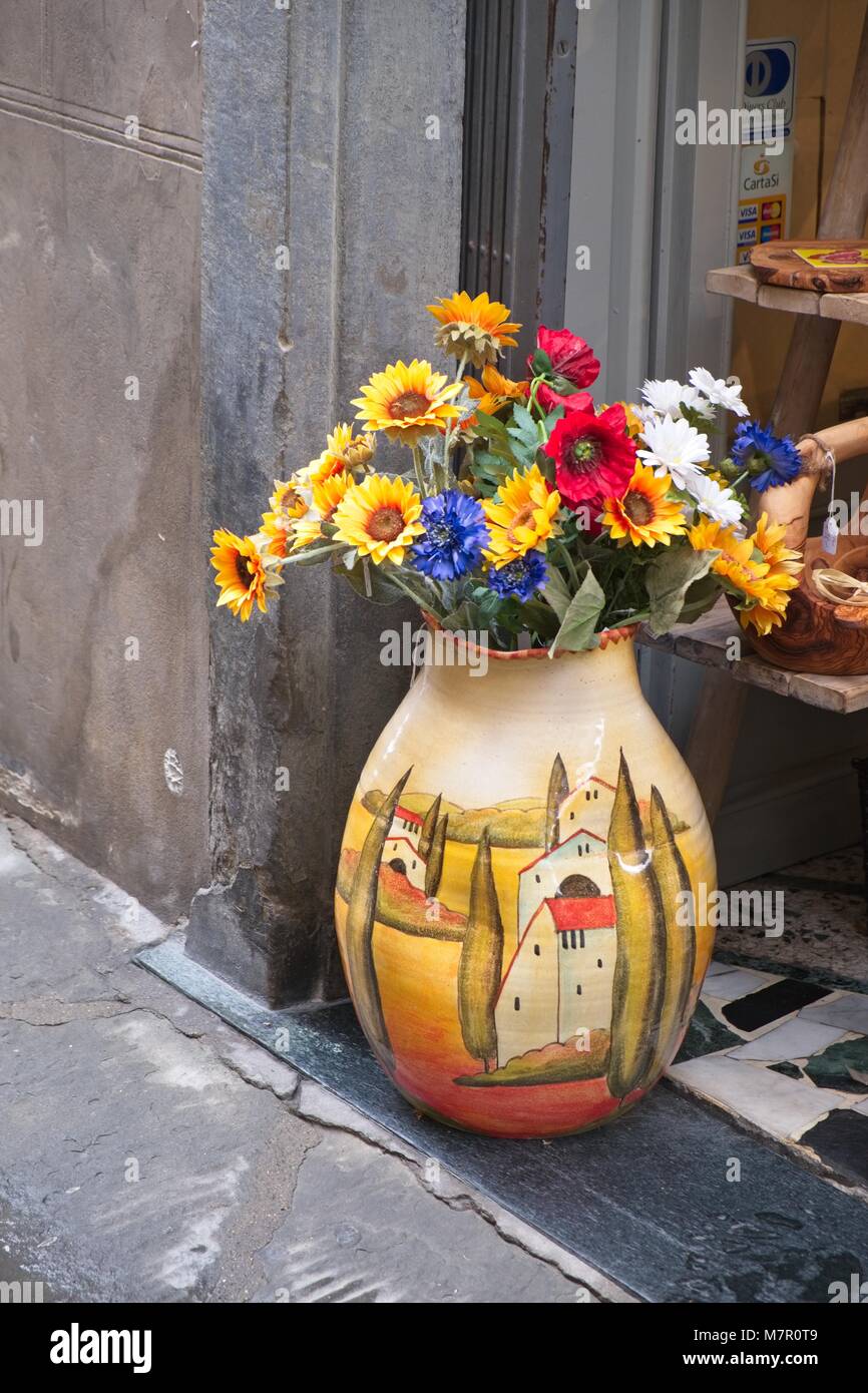 ORNAMENTAL VASE OF FLOWERS OUTSIDE SHOP IN CORTONA ITALY Stock Photo