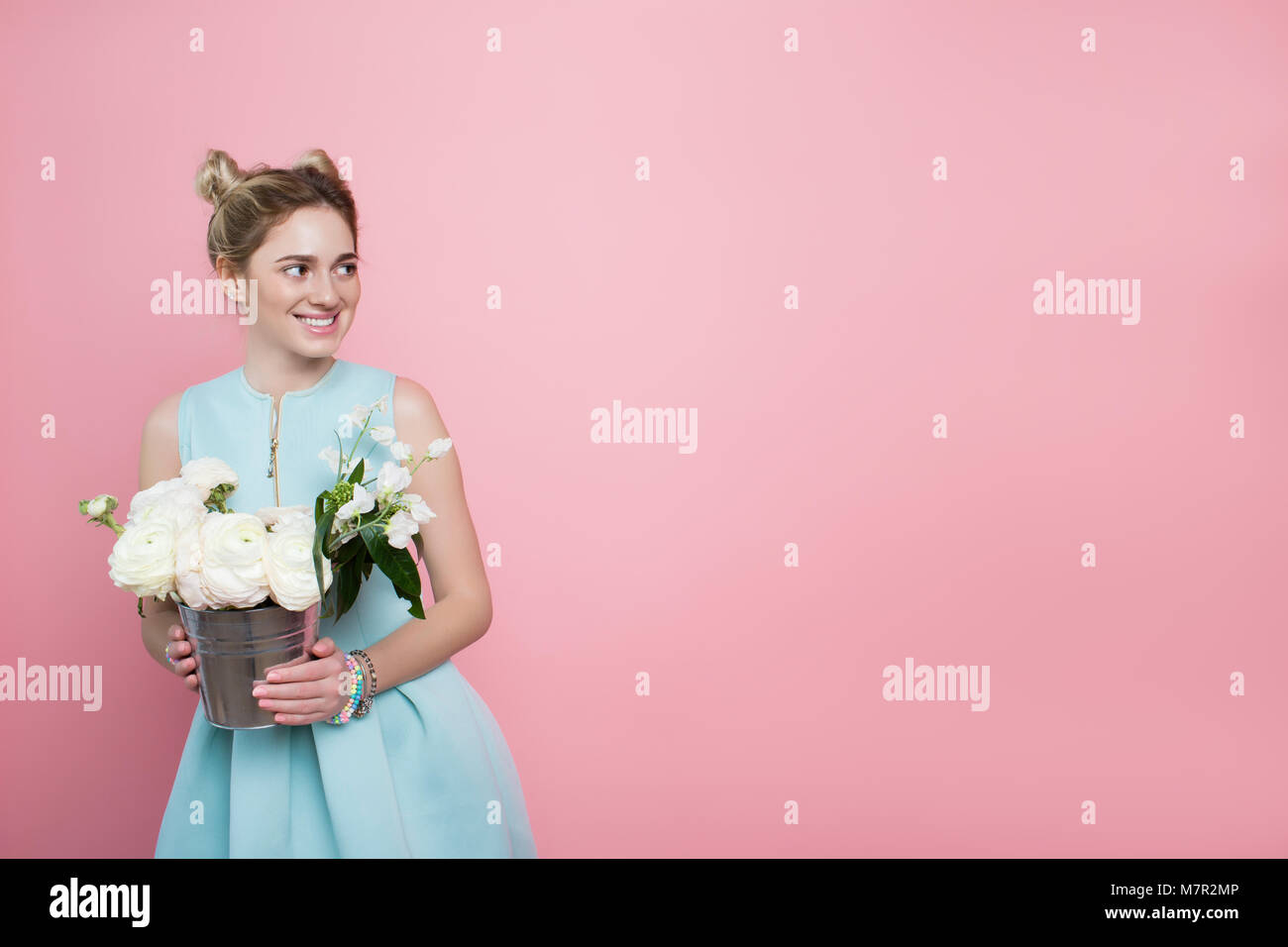 pretty woman with a bunch of flowers on a pink Stock Photo