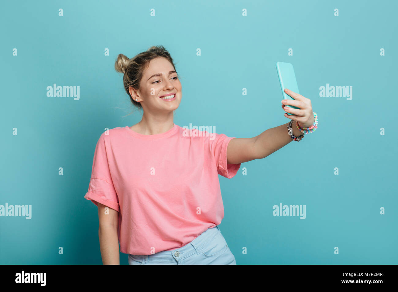 woman making photo on her smartphone blue background Stock Photo