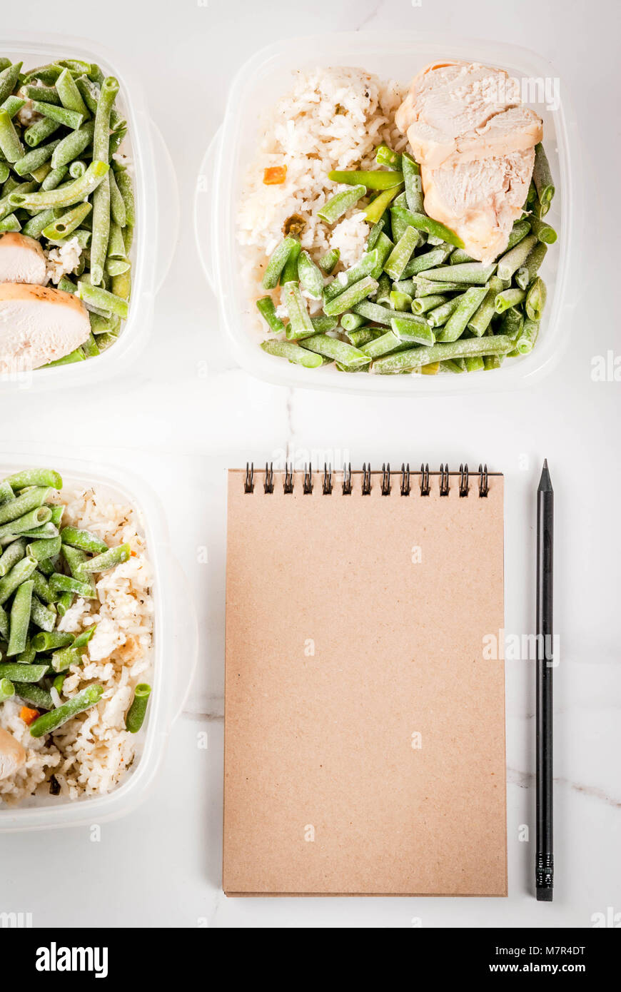 Food control, diet concept, orthorhysis. Healthy balanced meals, homemade lunches for work, office with rice, vegetables, chicken fillet. Notepad for  Stock Photo