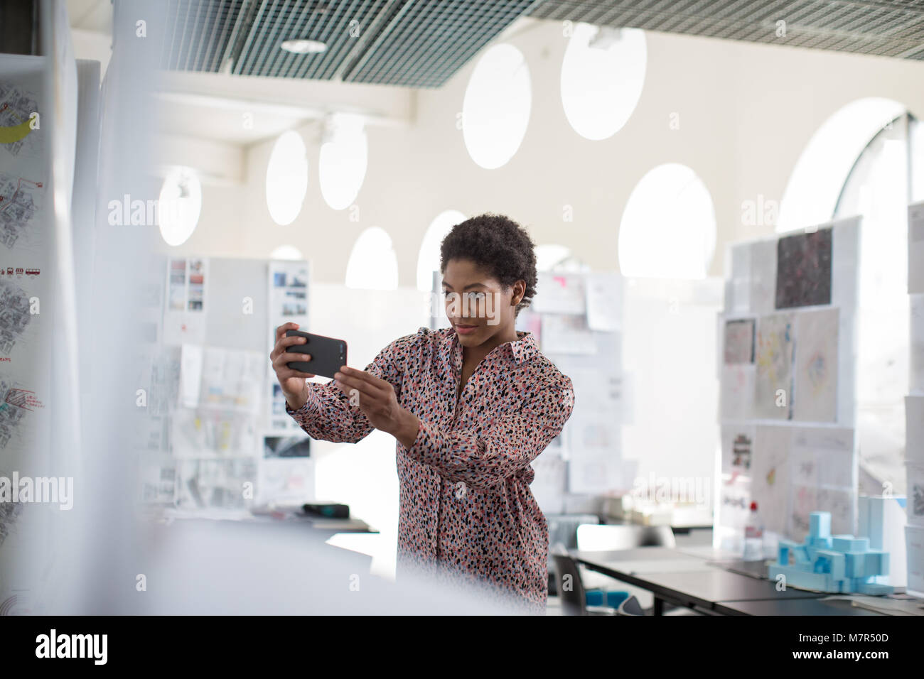 Designer taking photo of work with smartphone Stock Photo