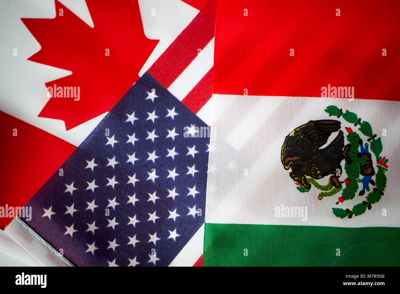 us stars and stripes flag with mexican flag and canadian maple leaf nafta flags Stock Photo