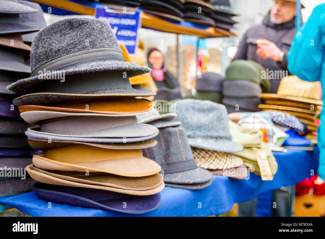 Stacked various colored men hats for sale, available at flea market