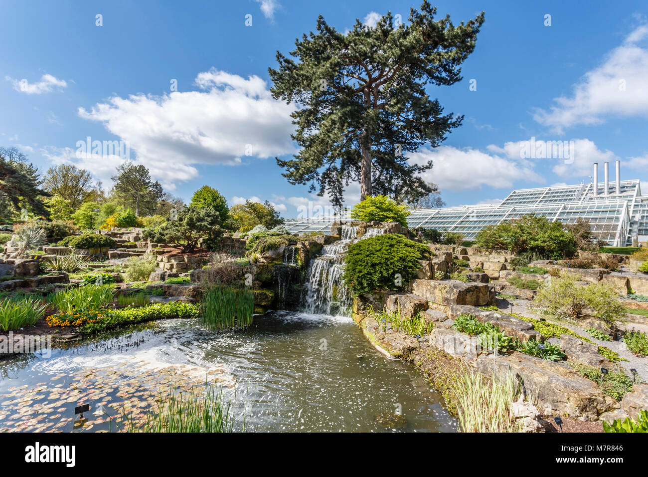 London, UK - April 18, 2014. Rock garden and Princess of Wales Conservatory in Kew Botanic Gardens. The gardens were founded in 1840. Stock Photo