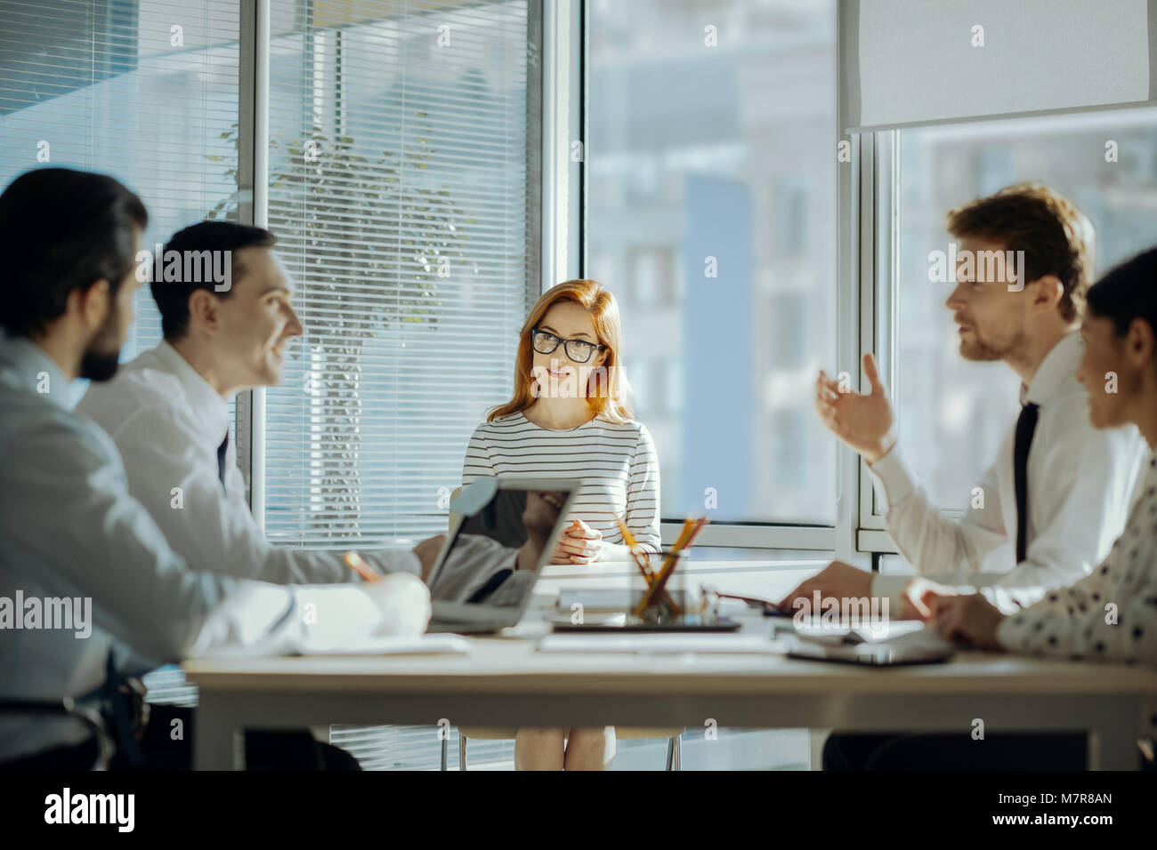 Pleasant young colleagues discussing tasks during meeting Stock Photo ...