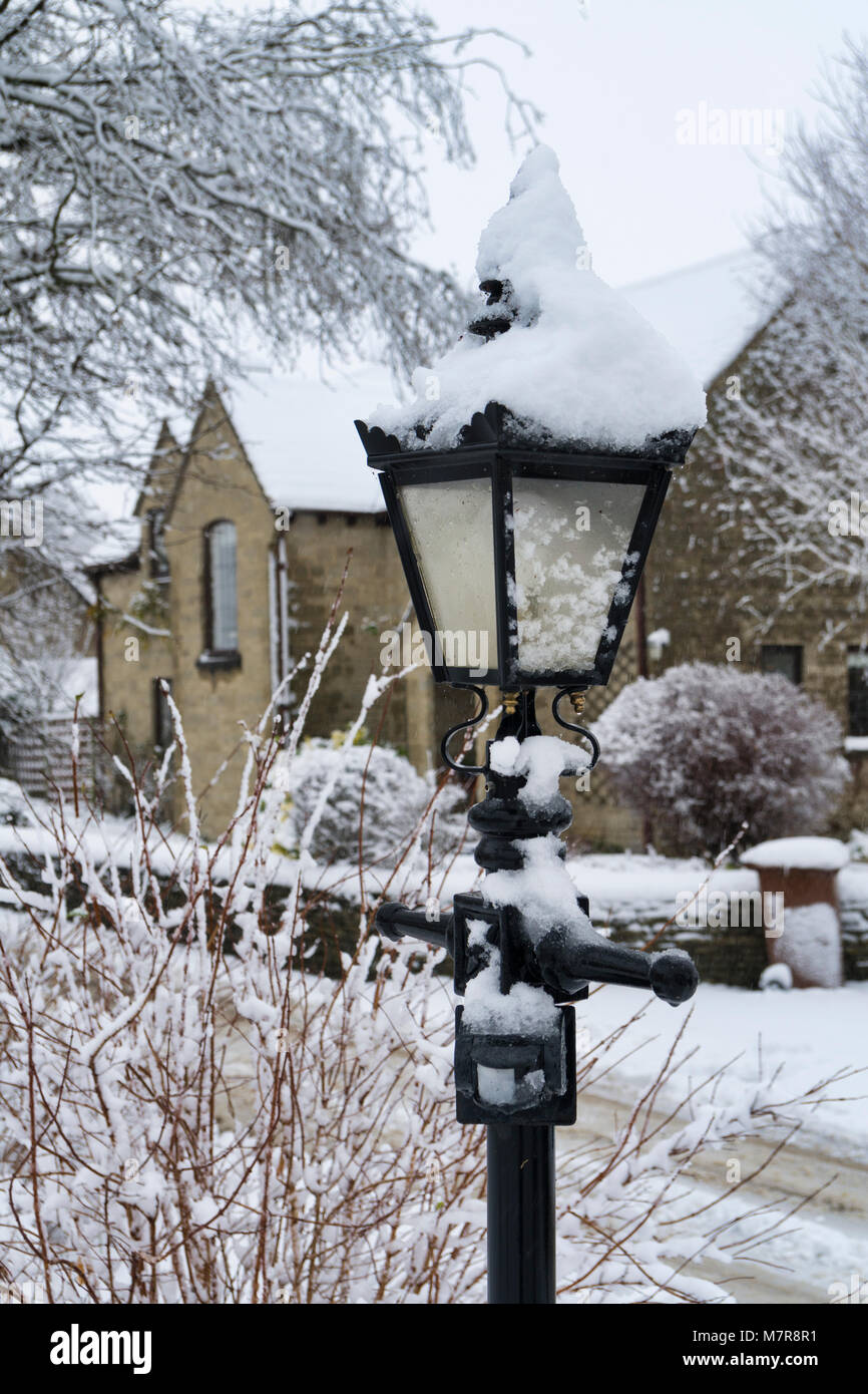 Old fashioned black cast iron lamp post covered in fresh snow Stock Photo