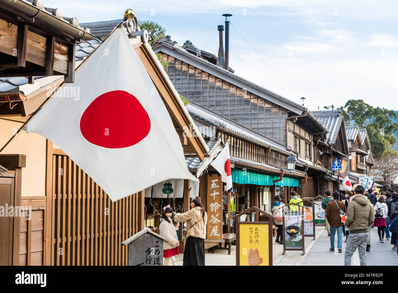 Japan, Ise. Oharai-machi pedestrian street with Edo period restored stores and shops. Japanese flag hanging from building and view along shopfronts. Stock Photo
