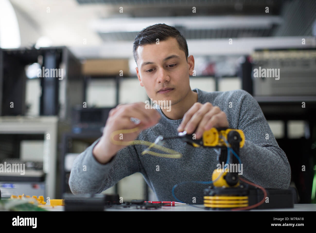 Young adult working on robotic arm Stock Photo - Alamy