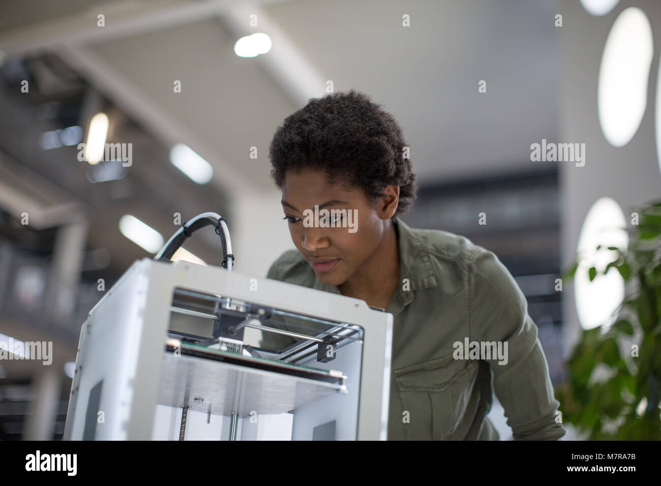 Female looking at 3D printer Stock Photo