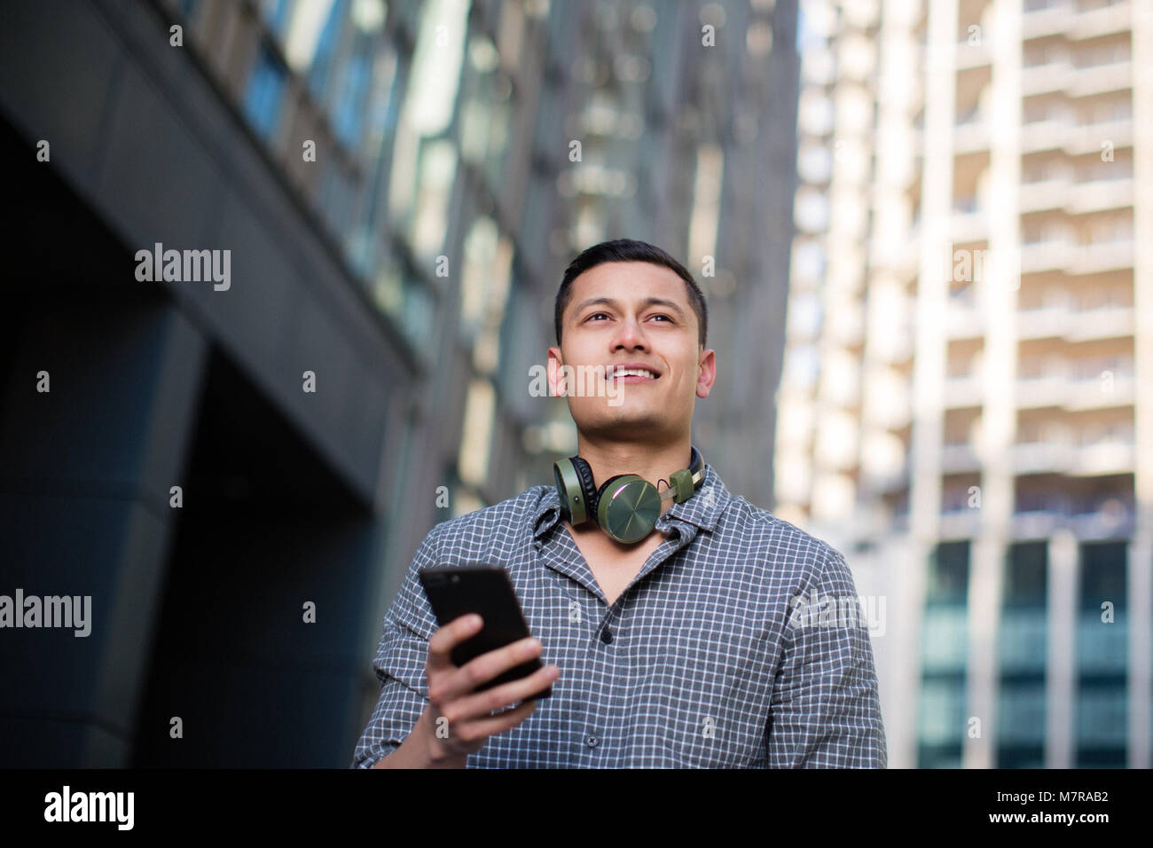 Young adult male with smartphone in city Stock Photo