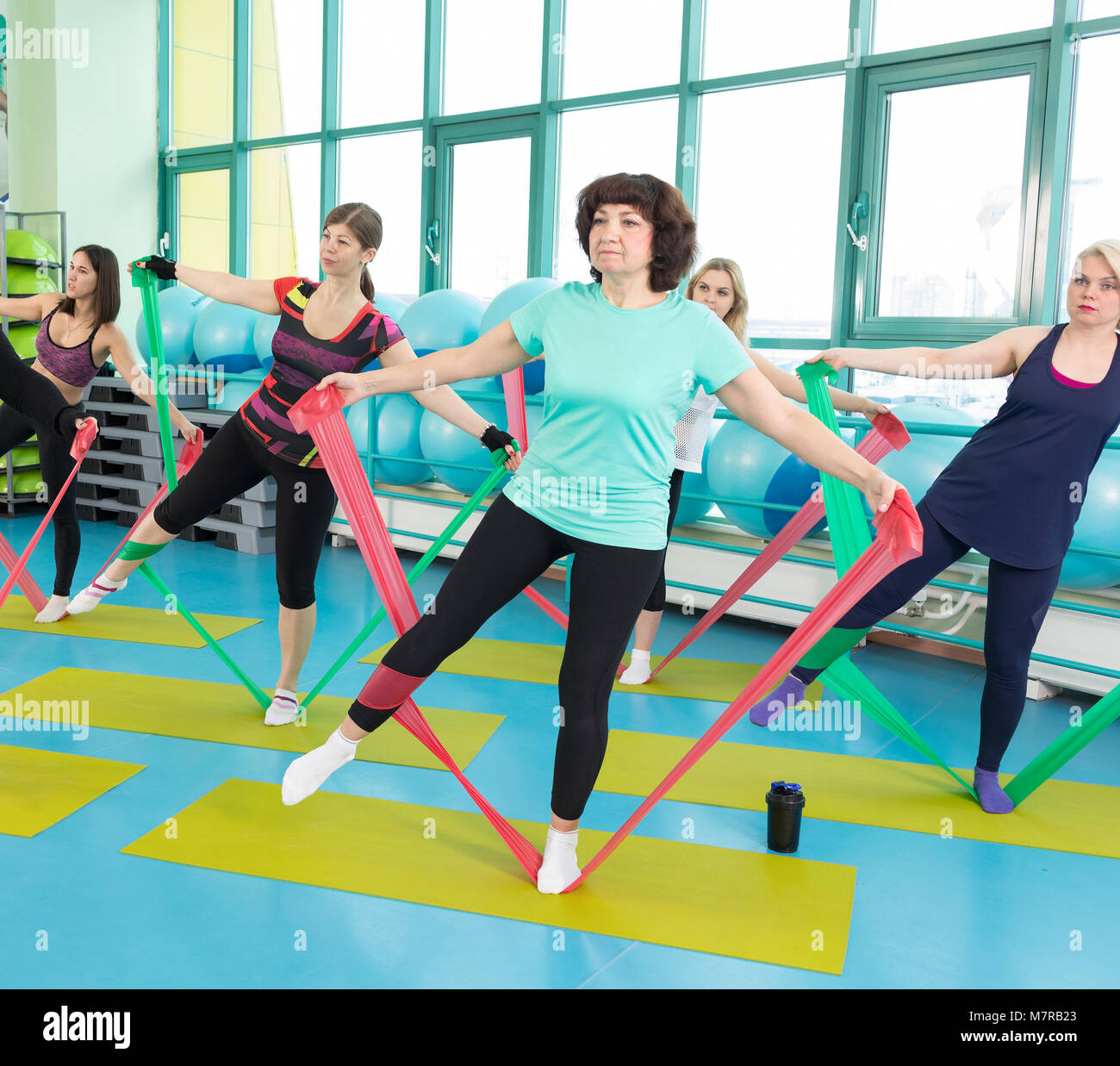 Women doing gym exercises using latex fitness bands Stock Photo