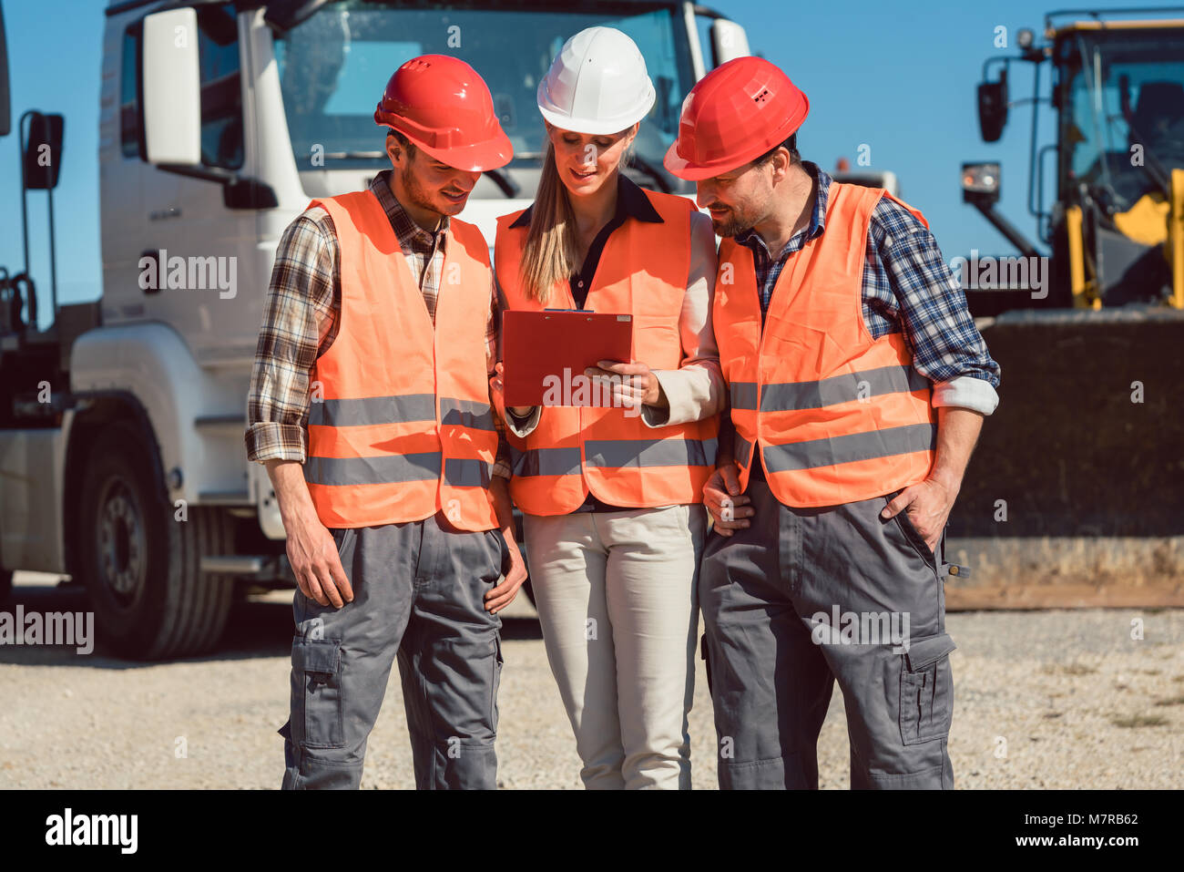 Truck drivers and dispatcher in front of lorries in freight forwarding company Stock Photo