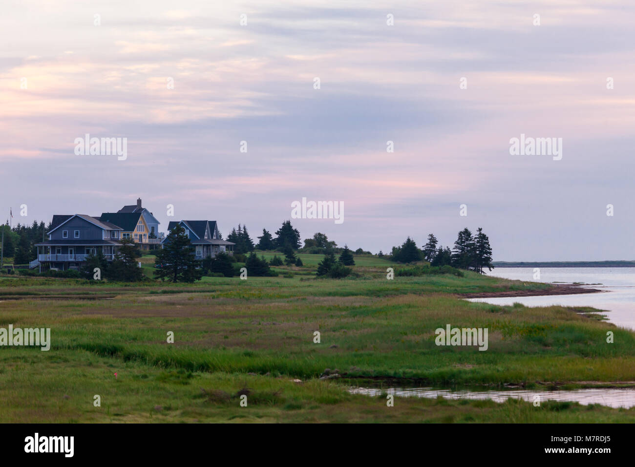 A small village of homes and lighthouse along the shoreline of Prince Edward Island on Canada's east coast. Stock Photo