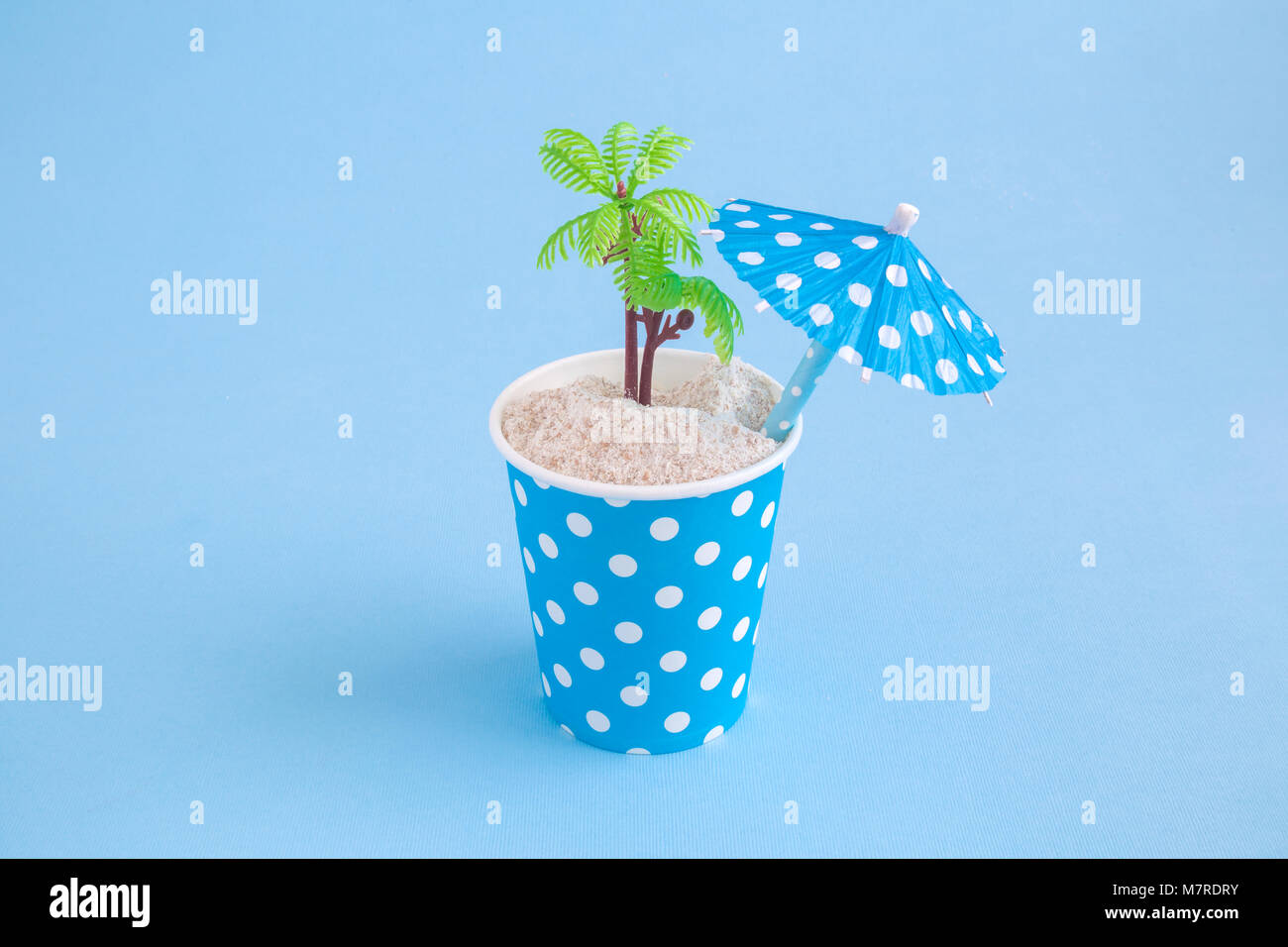 Paper cup polka design with sand palm tree and paper parasol on pastel ...