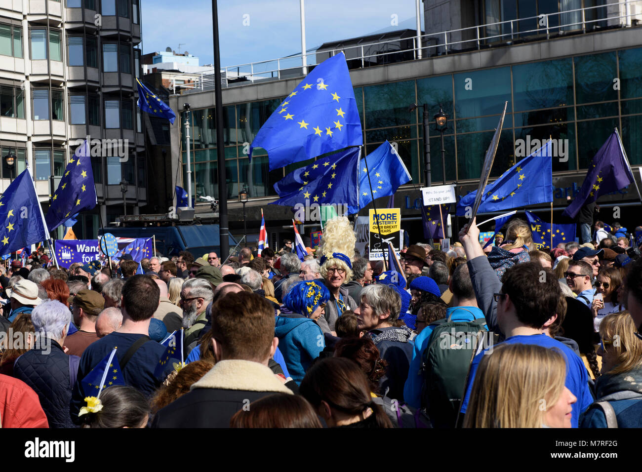 A crowd of EU supporters holding anti-Brexit placards and waving EU flags during the Unite for Europe march - anti-Brexit protest in London, UK. Stock Photo