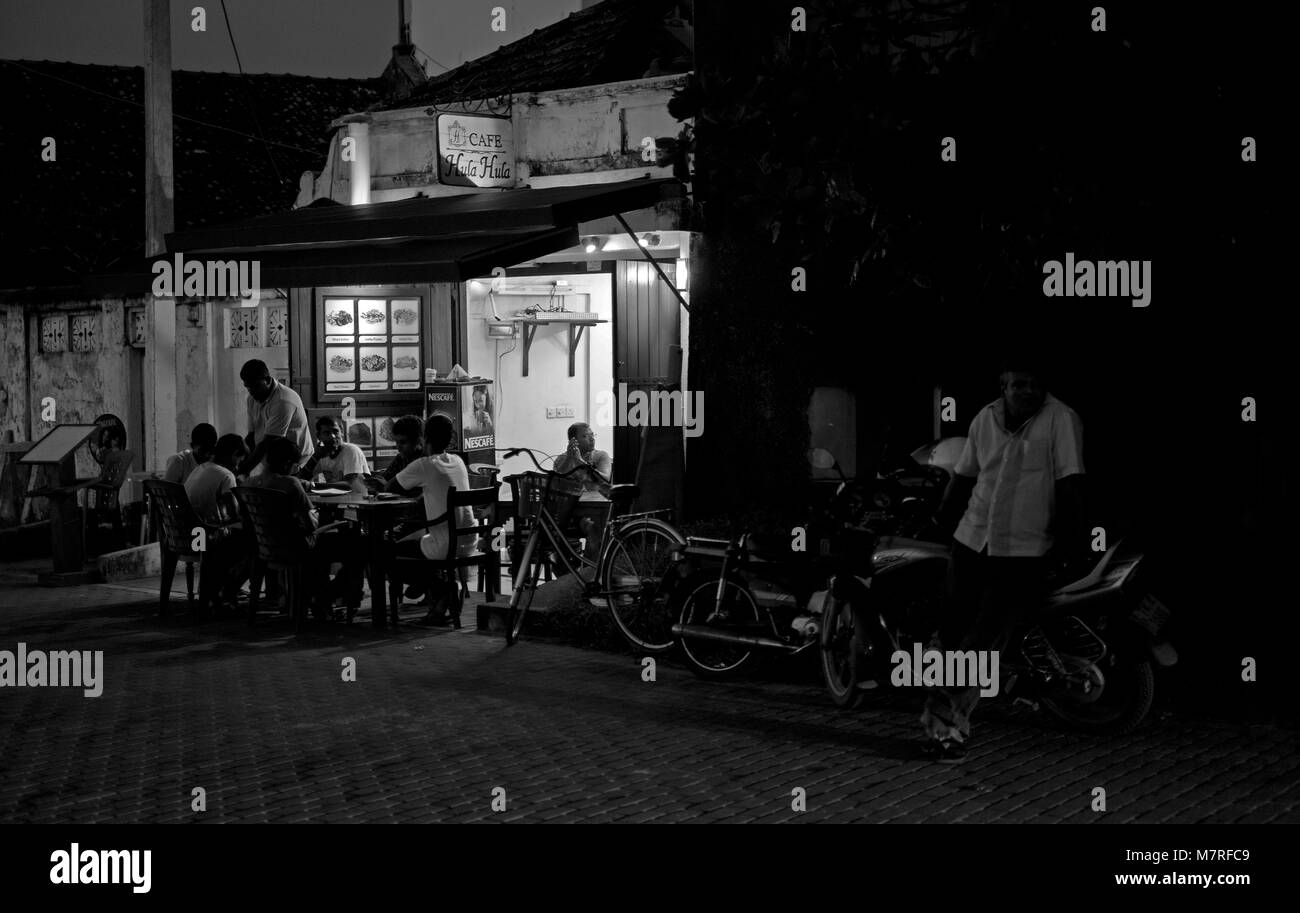 Men sit outside a cafe during the evening in Galle Fort, Sri Lanka Stock Photo