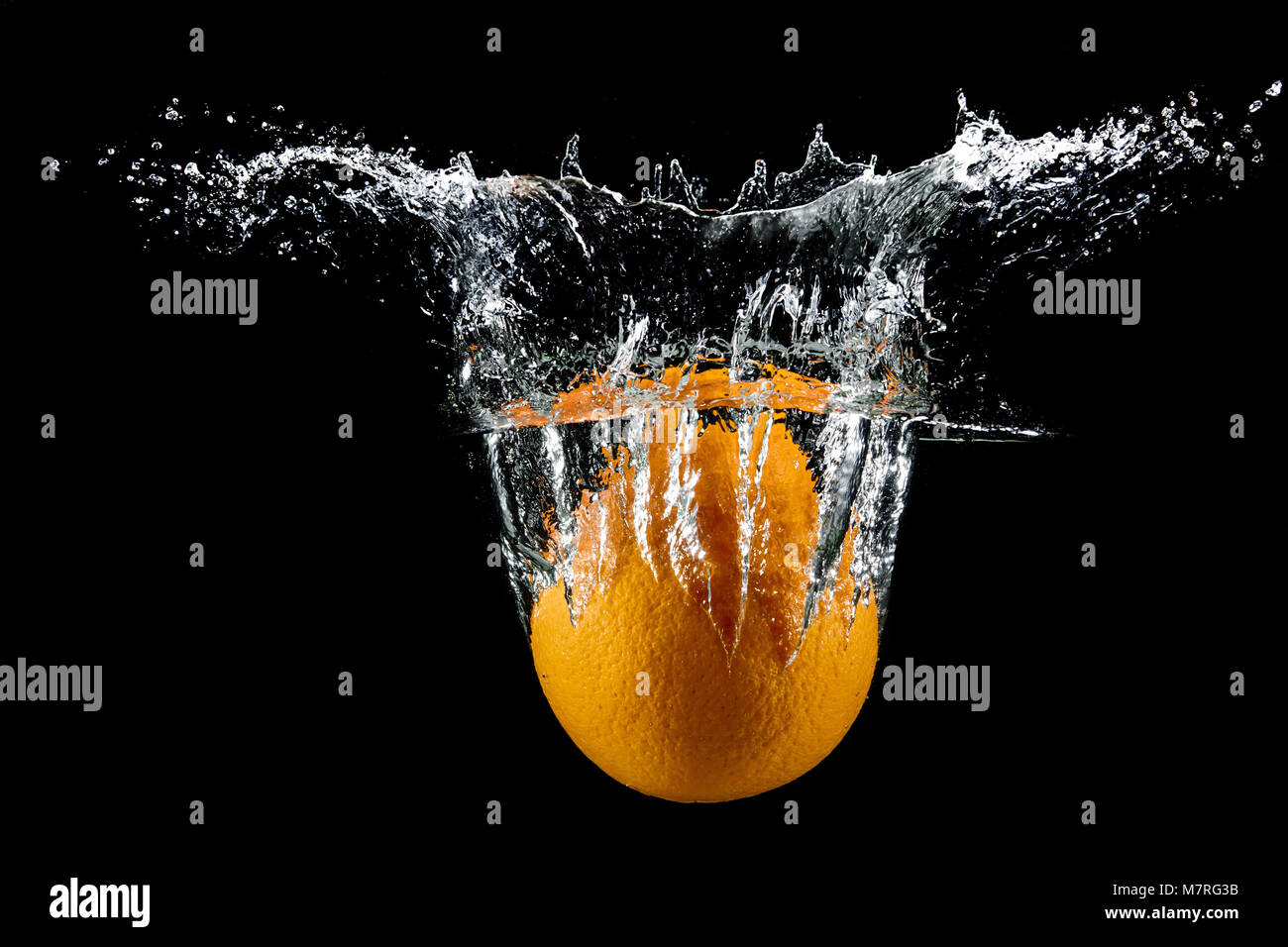fresh orange in water splash on black background Stock Photo - Alamy