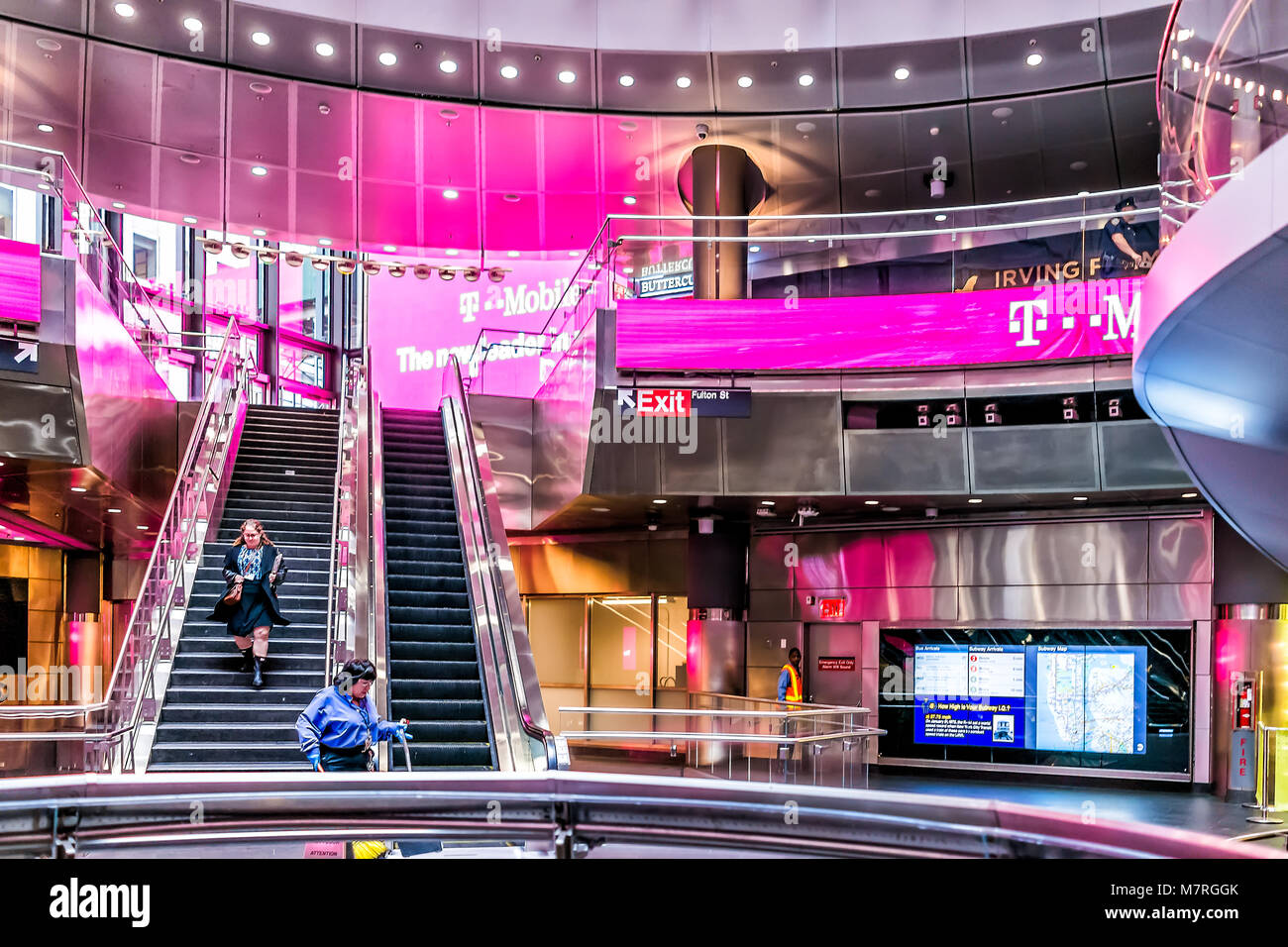 New York City, USA - October 30, 2017: Modern Fulton street NYC Subway Station in downtown interior with exit signs, T-Mobile pink carrier sign in Man Stock Photo