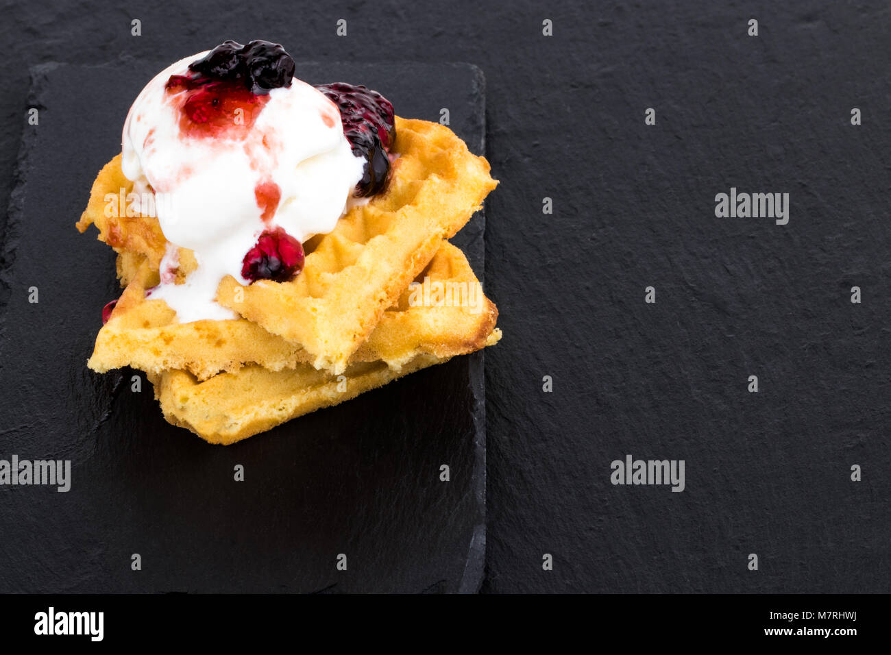 Plate of belgian waffles with ice cream and jam on dark background ...